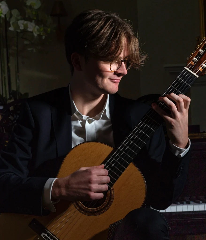Tom Hodgkinson holding a classical guitar for Fogel Academy testimonial
